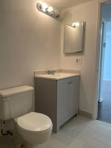 a bathroom with a toilet sink and mirror
