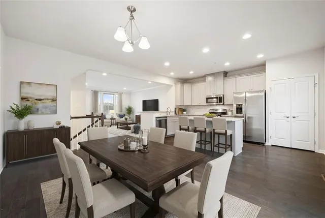 a view of a dining room and livingroom with furniture wooden floor a chandelier