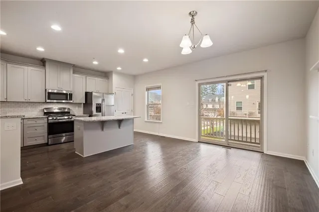 a large kitchen with hardwood floor and a window