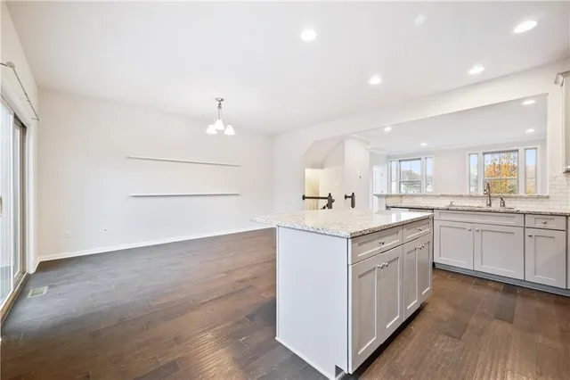 a kitchen with stainless steel appliances granite countertop a stove top oven a sink dishwasher and cabinets with wooden floor