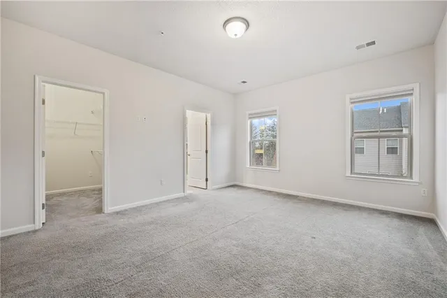 a spacious bedroom with a bed mirror and lamp