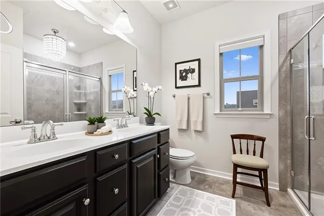 a bathroom with a double vanity sink a toilet and a mirror
