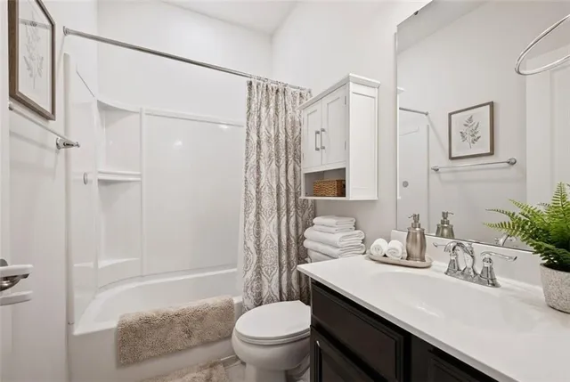 a bathroom with a granite countertop sink a toilet a mirror and shower