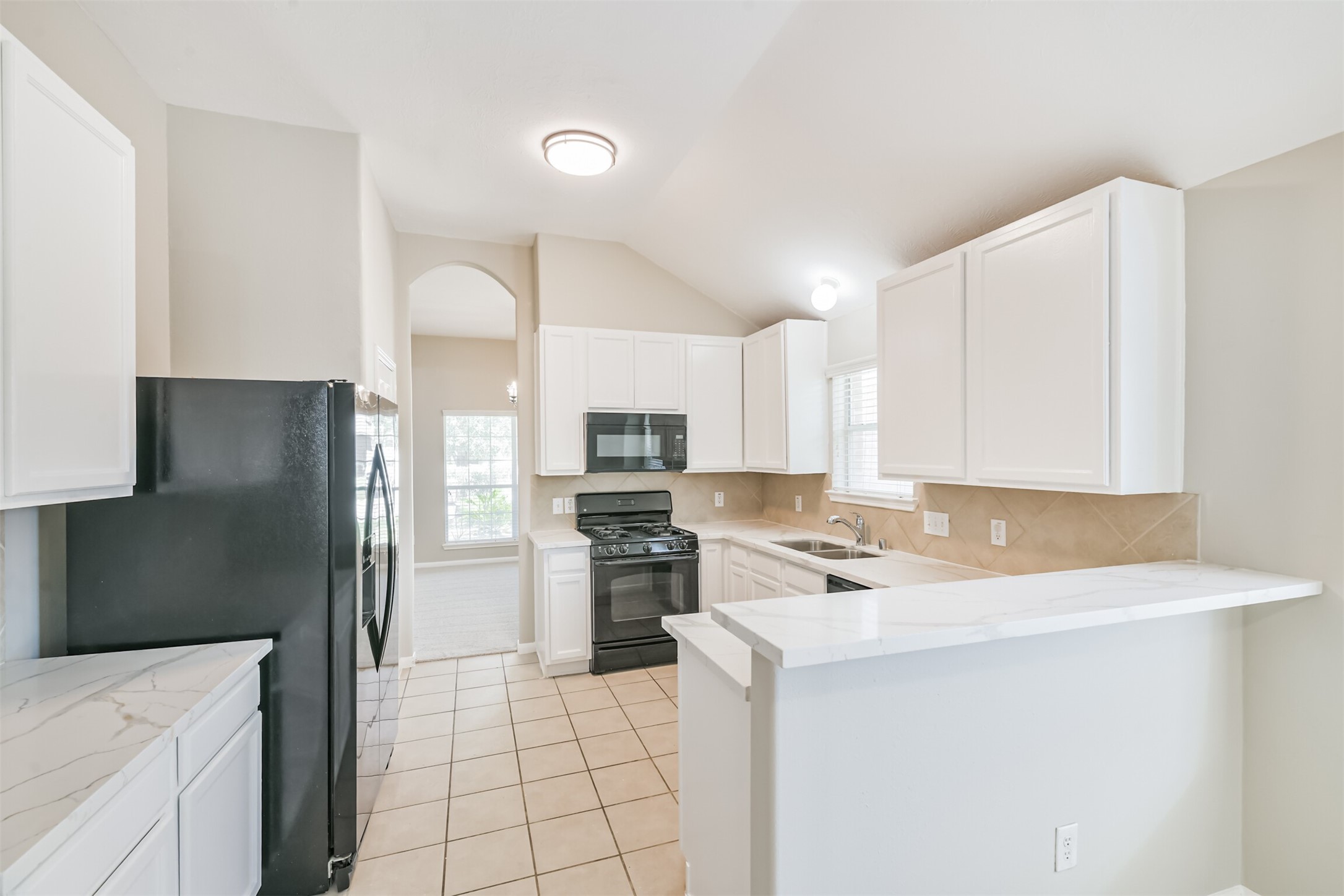 8331 Loetsch Ridge Way Spring, TX 77379 - Photo 4 of 31 The beautifully updated kitchen features crisp white cabinetry, quartz countertops, an undermount sink, abundant counter space, and an impressive amount of cabinet storage.