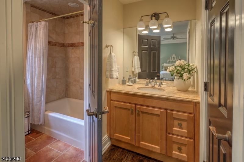 5 Burnett Road Mendham, NJ 07945 - Photo 32 of 50 a bathroom with a granite countertop sink a mirror and a bathtub