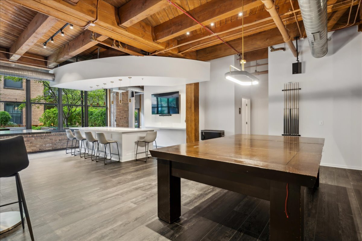 1040 West Adams Street, Unit 344 Chicago, IL 60607 - Photo 21 of 31 a dining room with wooden floor a glass table and chairs