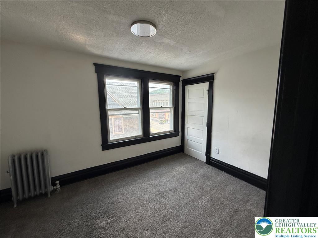 41 West Ridge Street Lansford, PA 18232 - Photo 31 of 40 A cozy bedroom with soft carpet, natural light from the windows, and ample space for relaxation.
