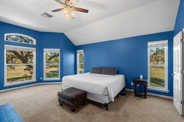 a bedroom with a bed and a large window