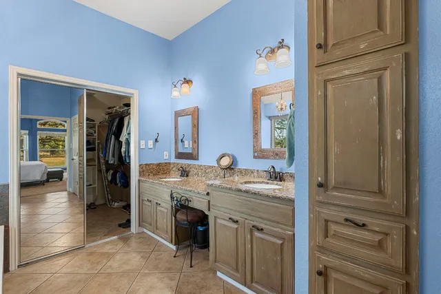 a en suite bathroom with a granite countertop sink and a mirror