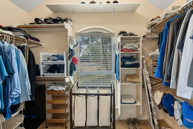 a view of walk in closet with clothes and shoes