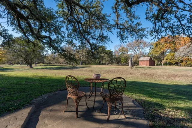 a view of a chairs and table in the garden