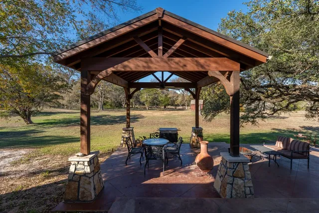 a view of a ocean with a table chairs and a umbrella