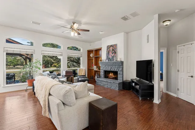 a living room with furniture a fireplace and a flat screen tv