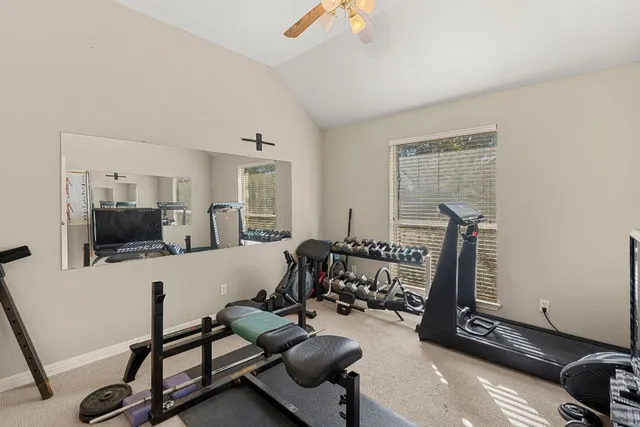 a living room with furniture gym equipment and a flat screen tv