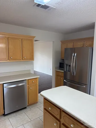 a kitchen with a refrigerator sink and cabinets