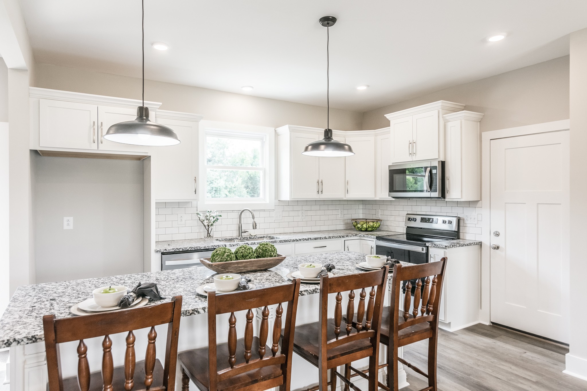 4839 Pulliam-Hardaway Road Springfield, TN 37172 - Photo 14 of 40 a kitchen with stainless steel appliances kitchen island granite countertop a stove a refrigerator a sink a dining table and chairs with wooden floor