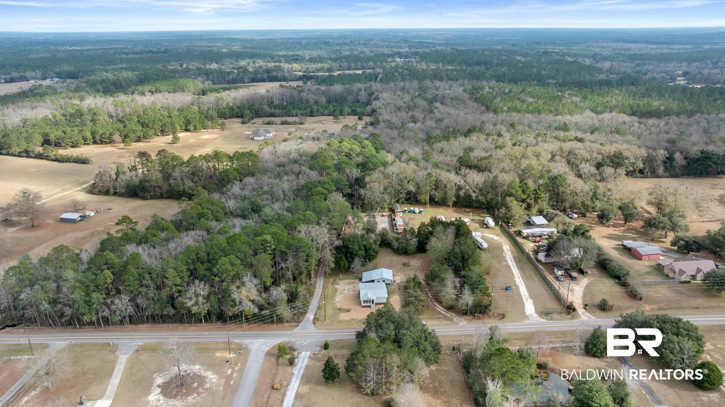 35780 Spring Road North Stapleton, AL 36578 - Photo 28 of 41 Aerial view of property and surrounding area with a heavily wooded area