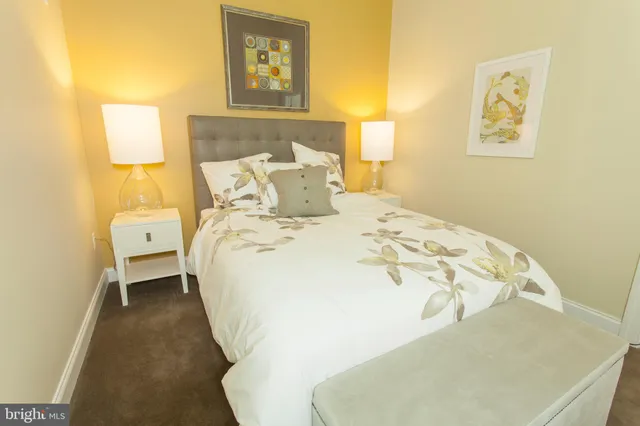 a bedroom with a bed and a painting on the wall