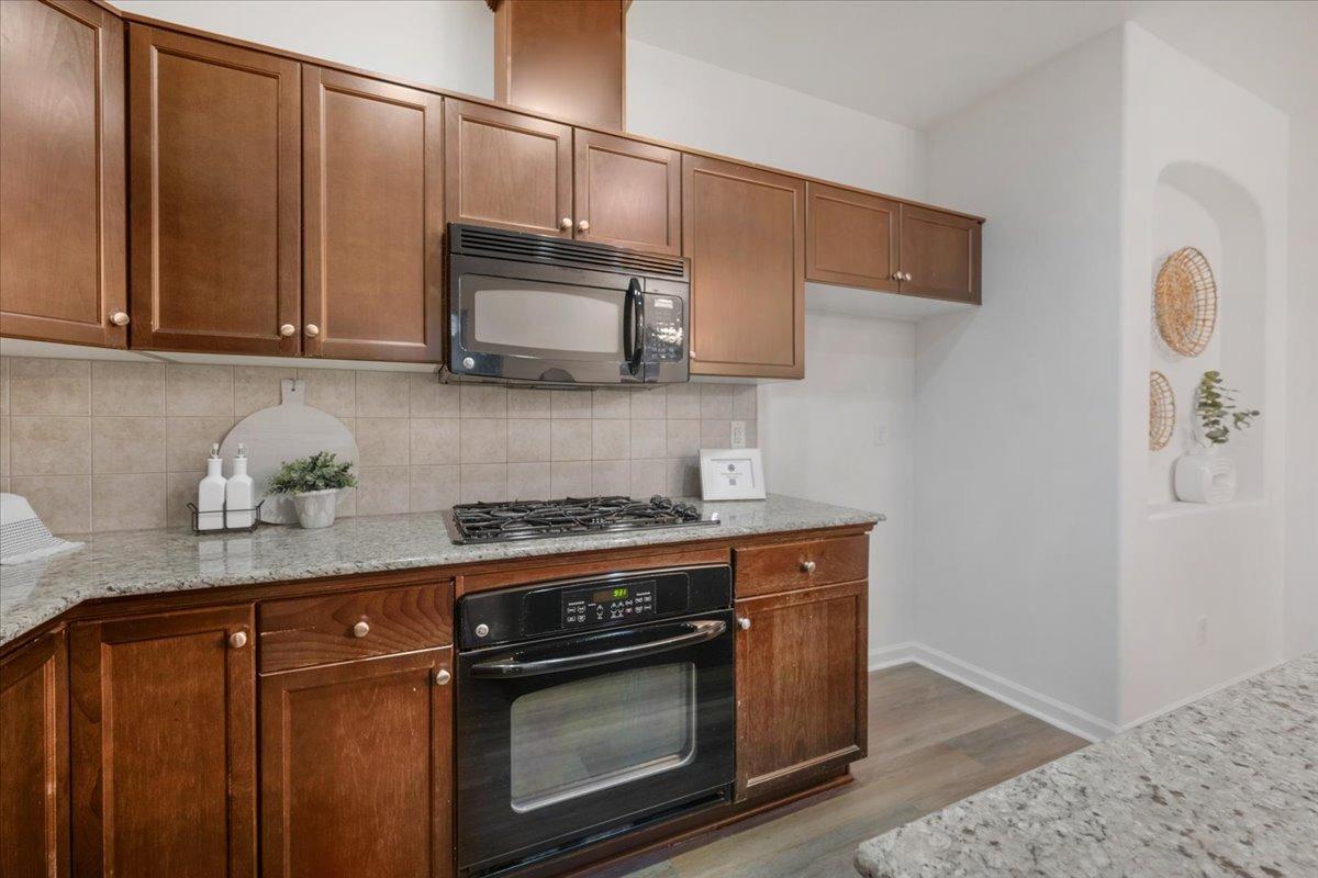 3755 Richmond Avenue Clovis, CA 93619 - Photo 11 of 30 a kitchen with stainless steel appliances granite countertop wooden cabinets a stove top oven a sink and dishwasher