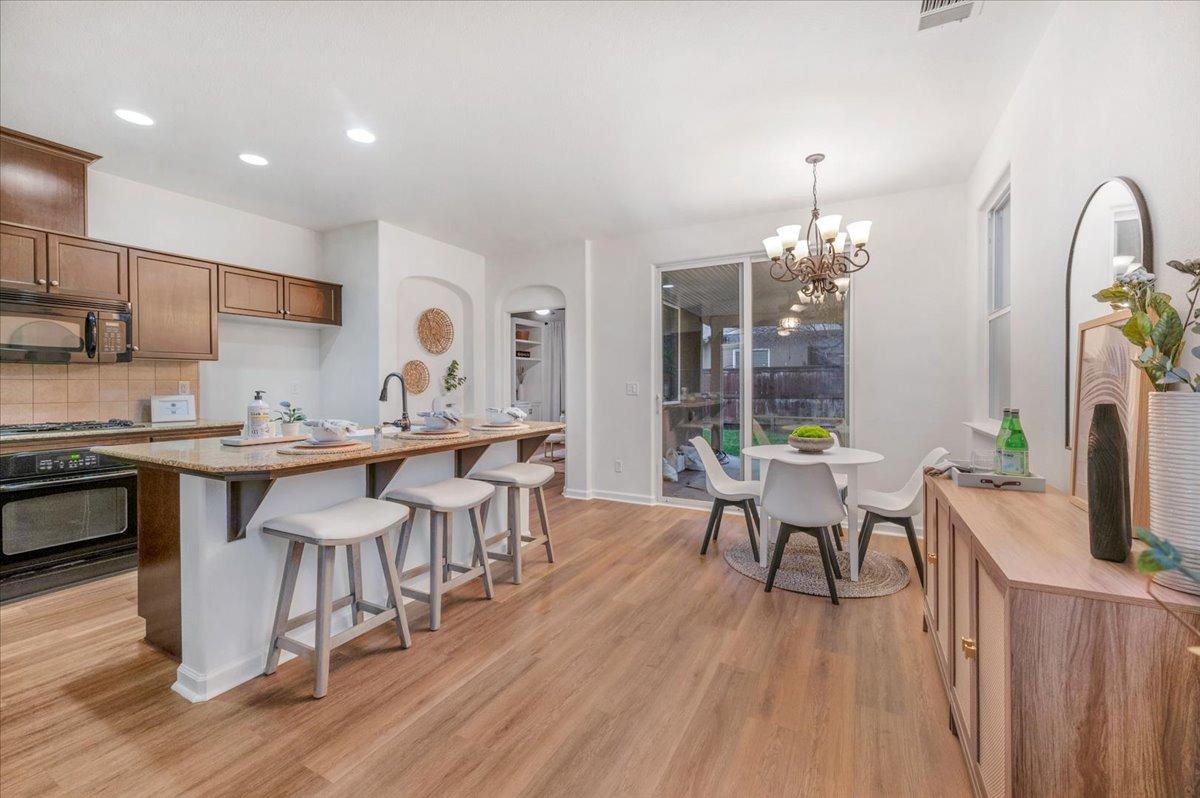 3755 Richmond Avenue Clovis, CA 93619 - Photo 4 of 30 a dining room with furniture a chandelier and wooden floor