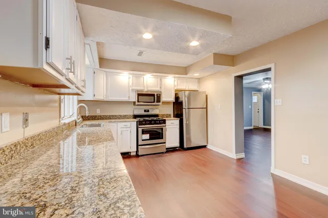 a kitchen with stainless steel appliances a refrigerator and a stove top oven