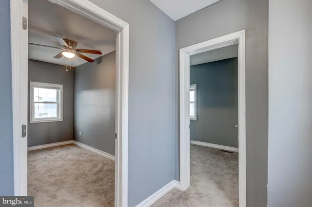 an empty room with a window and a fan