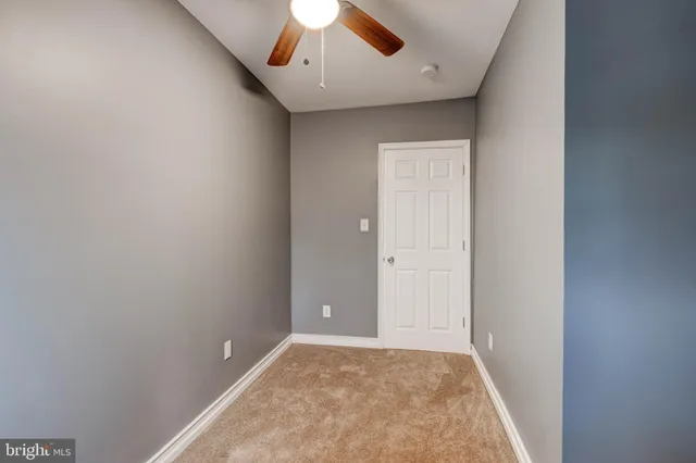 an empty room with chandelier fan
