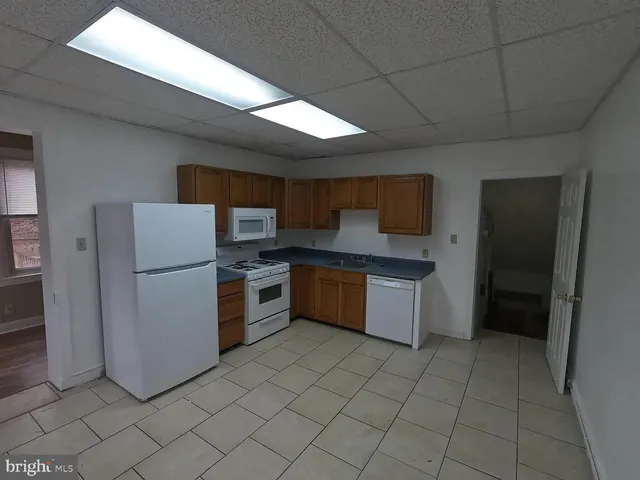 a kitchen with a refrigerator sink and cabinets