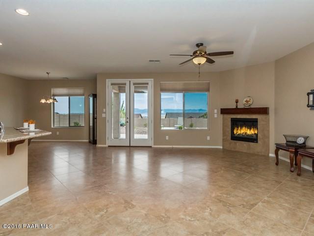 1101 Rusty Nail Road Prescott Valley, AZ 86314 - Photo 3 of 29 an empty room with fireplace chandelier fan and windows