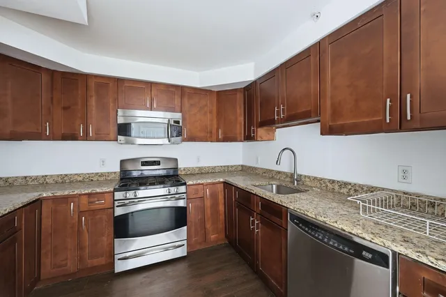 a kitchen with granite countertop a sink stove and cabinets