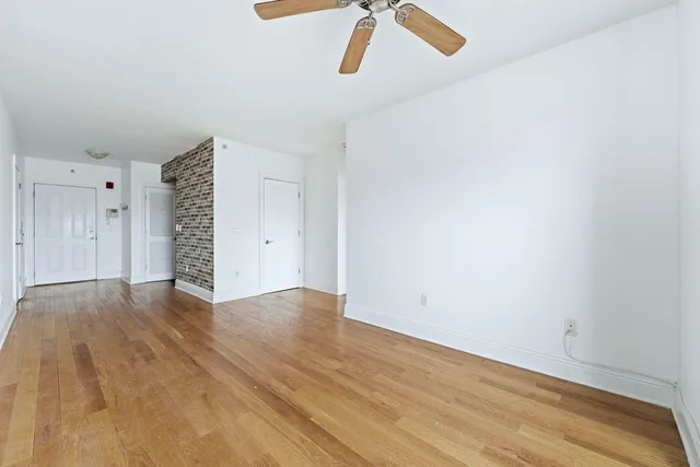 a view of empty room with wooden floor