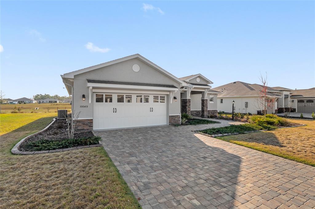 10049 Southwest 107th Lane Ocala, FL 34481 - Photo 1 of 67 a front view of a house with a yard