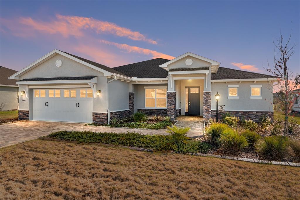 10049 Southwest 107th Lane Ocala, FL 34481 - Photo 2 of 67 a front view of a house with a yard