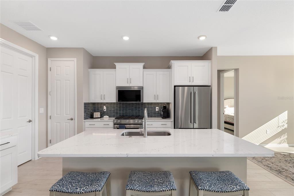 10049 Southwest 107th Lane Ocala, FL 34481 - Photo 21 of 67 a kitchen with stainless steel appliances granite countertop a sink refrigerator and microwave