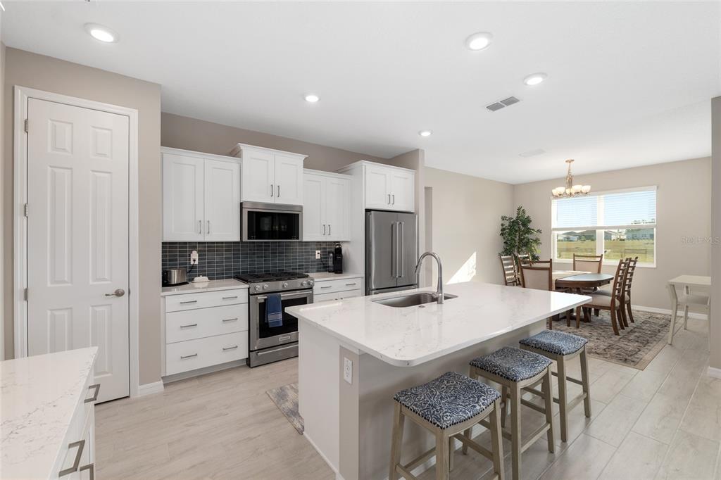 10049 Southwest 107th Lane Ocala, FL 34481 - Photo 22 of 67 a kitchen with a dining table chairs appliances and cabinets