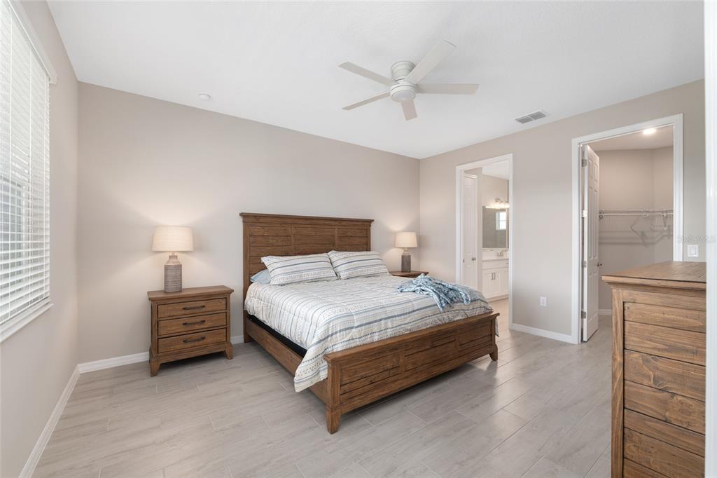 10049 Southwest 107th Lane Ocala, FL 34481 - Photo 32 of 67 a bedroom with a bed and a chandelier