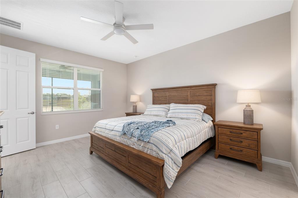10049 Southwest 107th Lane Ocala, FL 34481 - Photo 33 of 67 a bedroom with a bed next to a window and a chandelier
