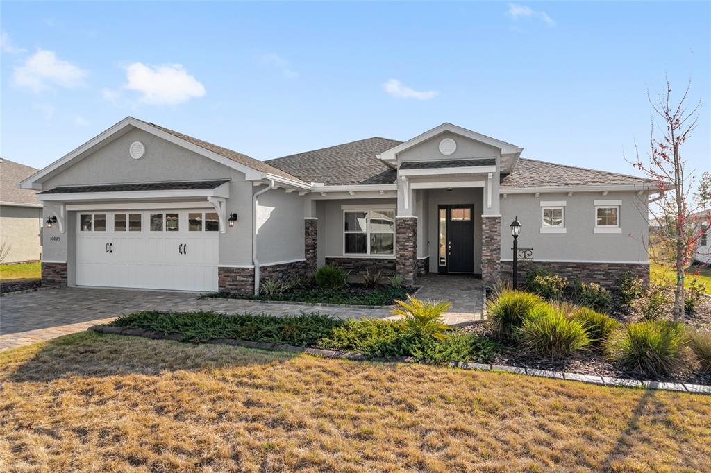 10049 Southwest 107th Lane Ocala, FL 34481 - Photo 5 of 67 a front view of a house with a yard and garage