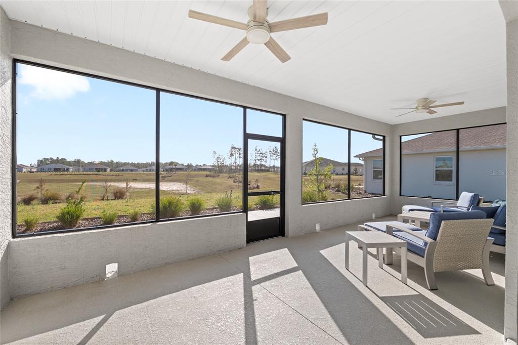 10049 Southwest 107th Lane Ocala, FL 34481 - Photo 52 of 67 a living room with furniture and floor to ceiling windows