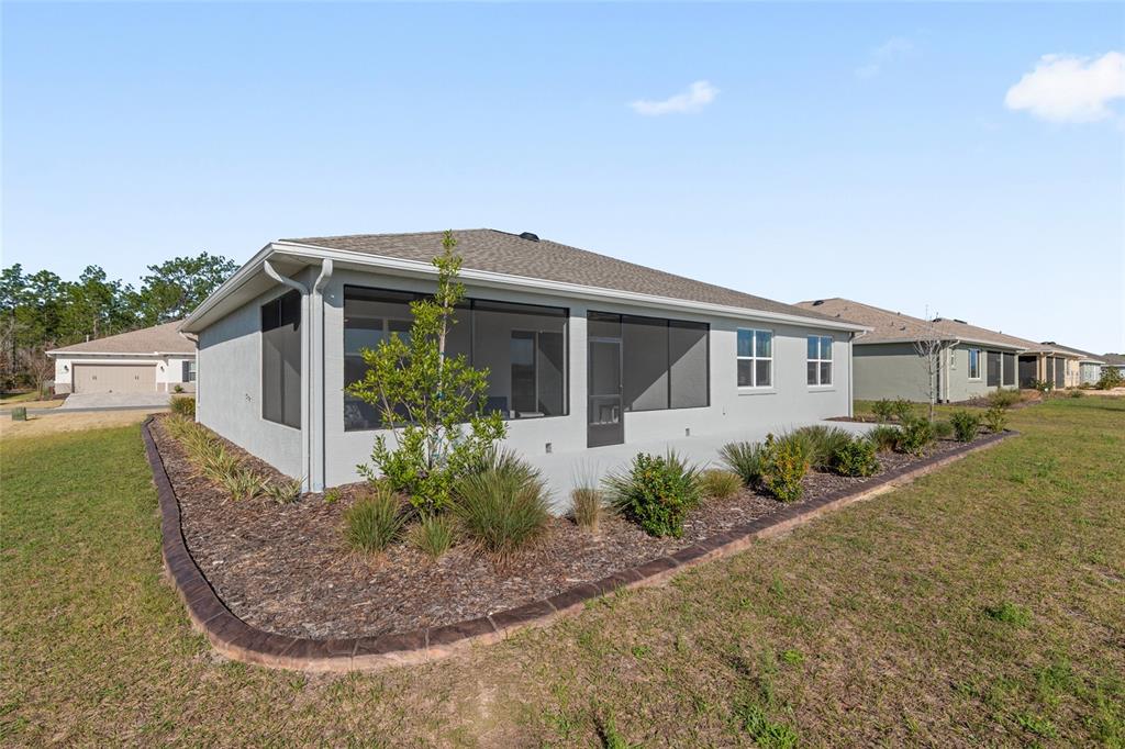 10049 Southwest 107th Lane Ocala, FL 34481 - Photo 62 of 67 a front view of a house with garden
