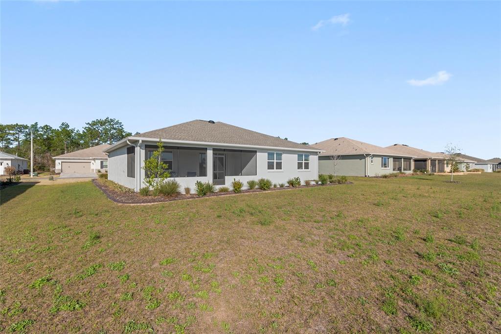 10049 Southwest 107th Lane Ocala, FL 34481 - Photo 64 of 67 a front view of a house with a garden