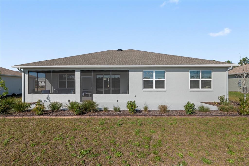 10049 Southwest 107th Lane Ocala, FL 34481 - Photo 65 of 67 a front view of a house with a garden