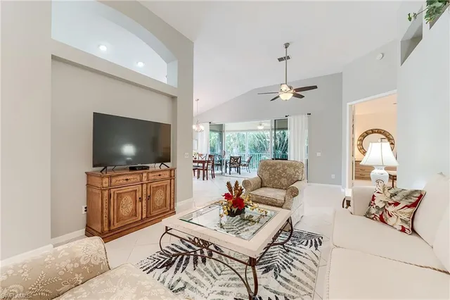 a living room with furniture a flat screen tv and a large window