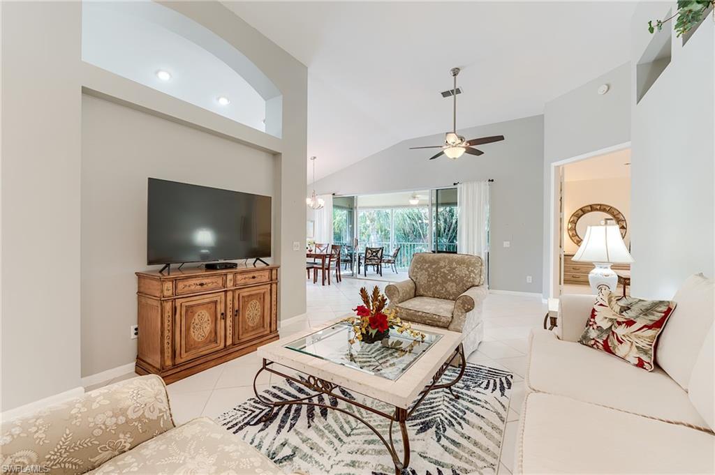 23166 Rosedale Drive, Unit 201 Estero, FL 34135 - Photo 11 of 40 a living room with furniture a flat screen tv and a large window