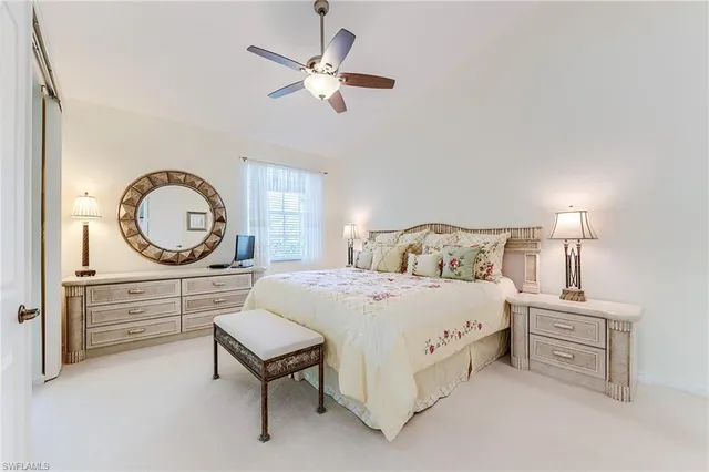 a spacious bedroom with a bed a chandelier with a dresser and a chandelier