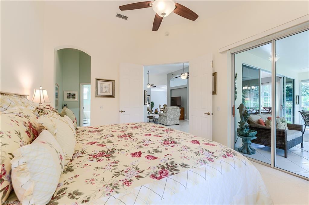 23166 Rosedale Drive, Unit 201 Estero, FL 34135 - Photo 15 of 40 a bedroom with a bed and lamp