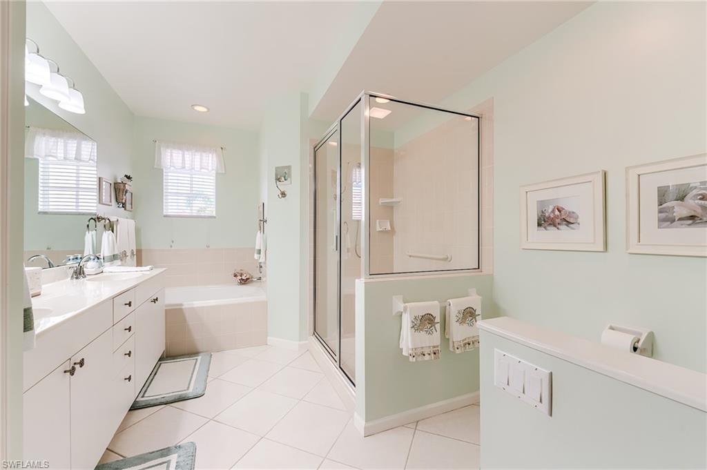 23166 Rosedale Drive, Unit 201 Estero, FL 34135 - Photo 16 of 40 a bathroom with a tub sink and mirror