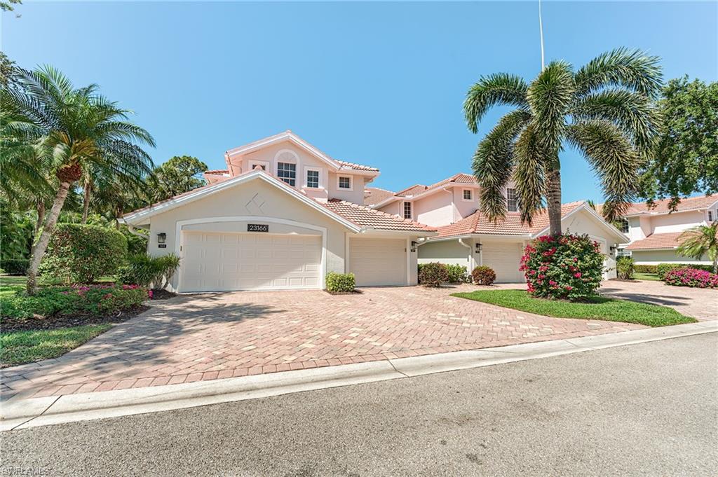 23166 Rosedale Drive, Unit 201 Estero, FL 34135 - Photo 35 of 40 a view of a house with a yard and palm trees