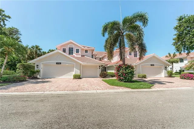 front view of a house with a yard and trees