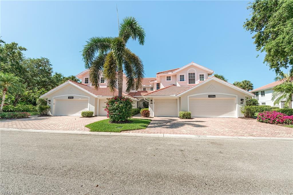 23166 Rosedale Drive, Unit 201 Estero, FL 34135 - Photo 37 of 40 front view of a house with a yard and trees